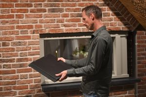 Man bekijkt dakpannen in de showroom van Van Wiggen Bouw in Vianen voor gevel- en dakafwerking