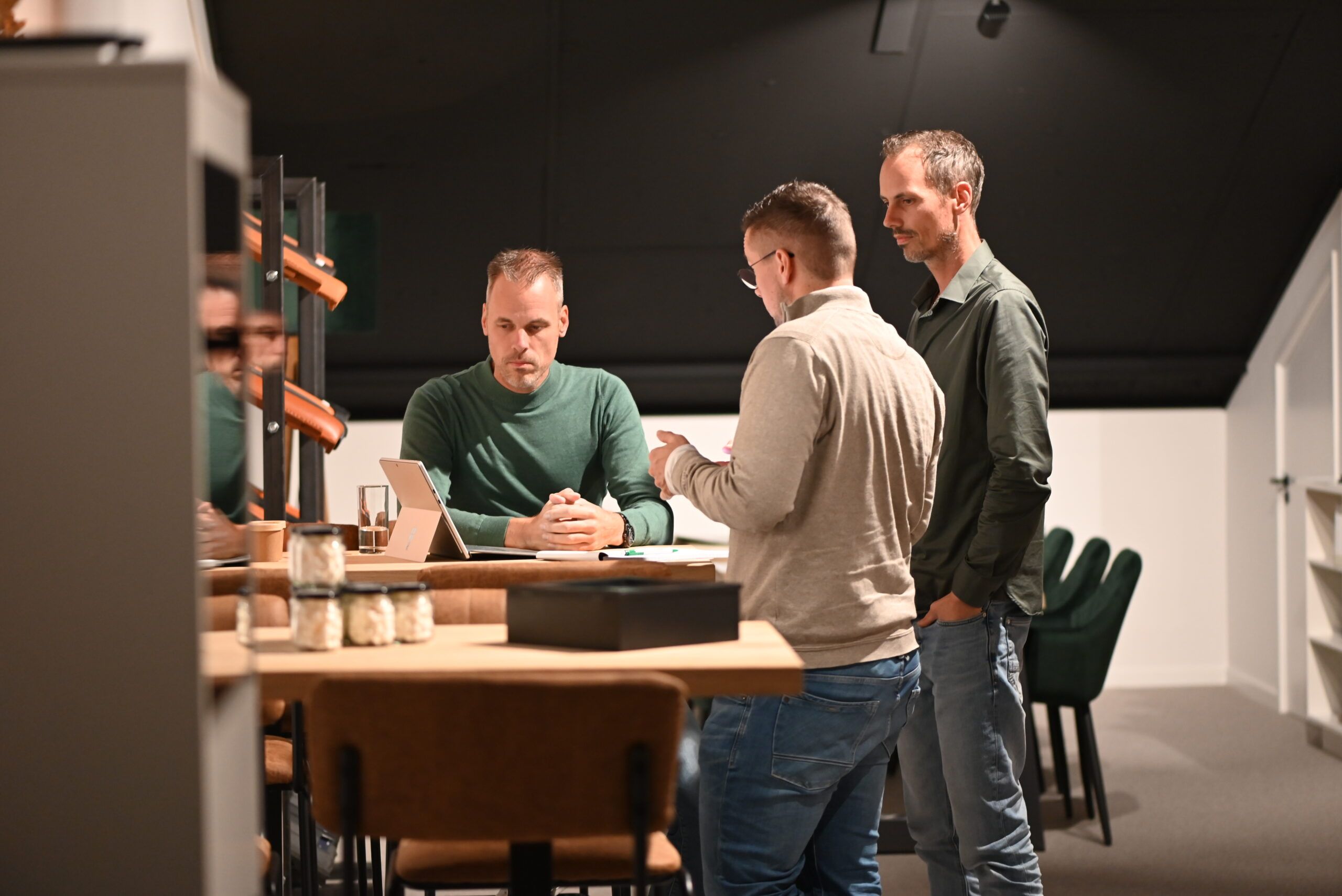 Drie collega’s in overleg aan tafel in de showroom van Van Wiggen Bouw in Vianen