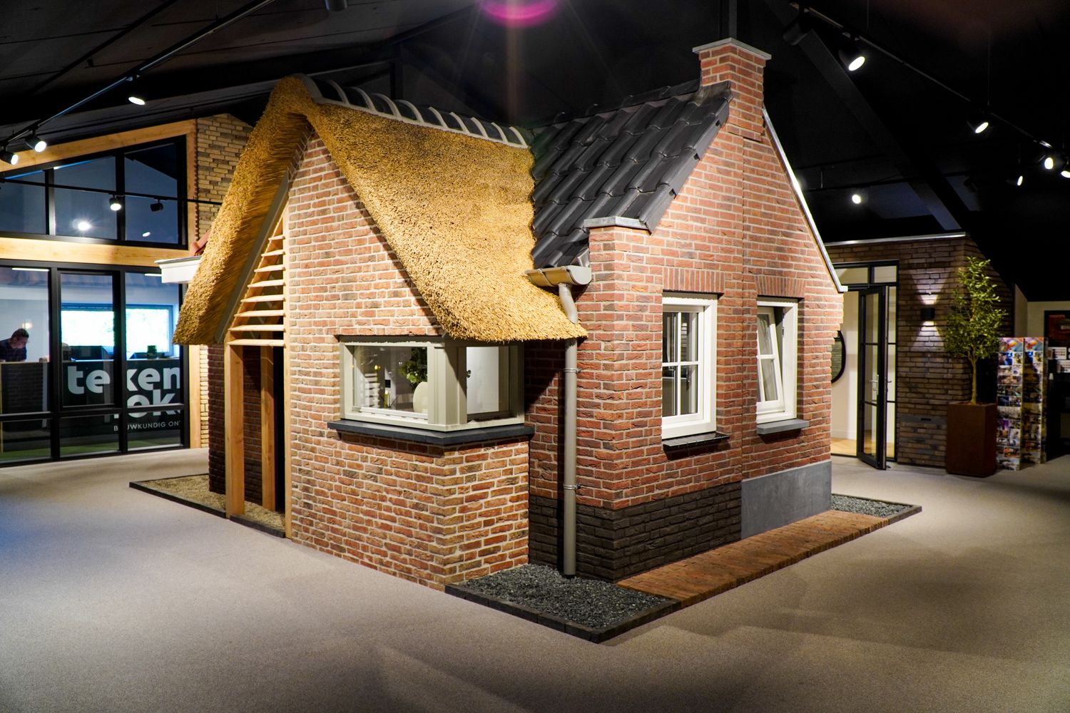 Een klant in gesprek met een calculator van Van Wiggen Bouw in de showroom over een nieuw bouwproject