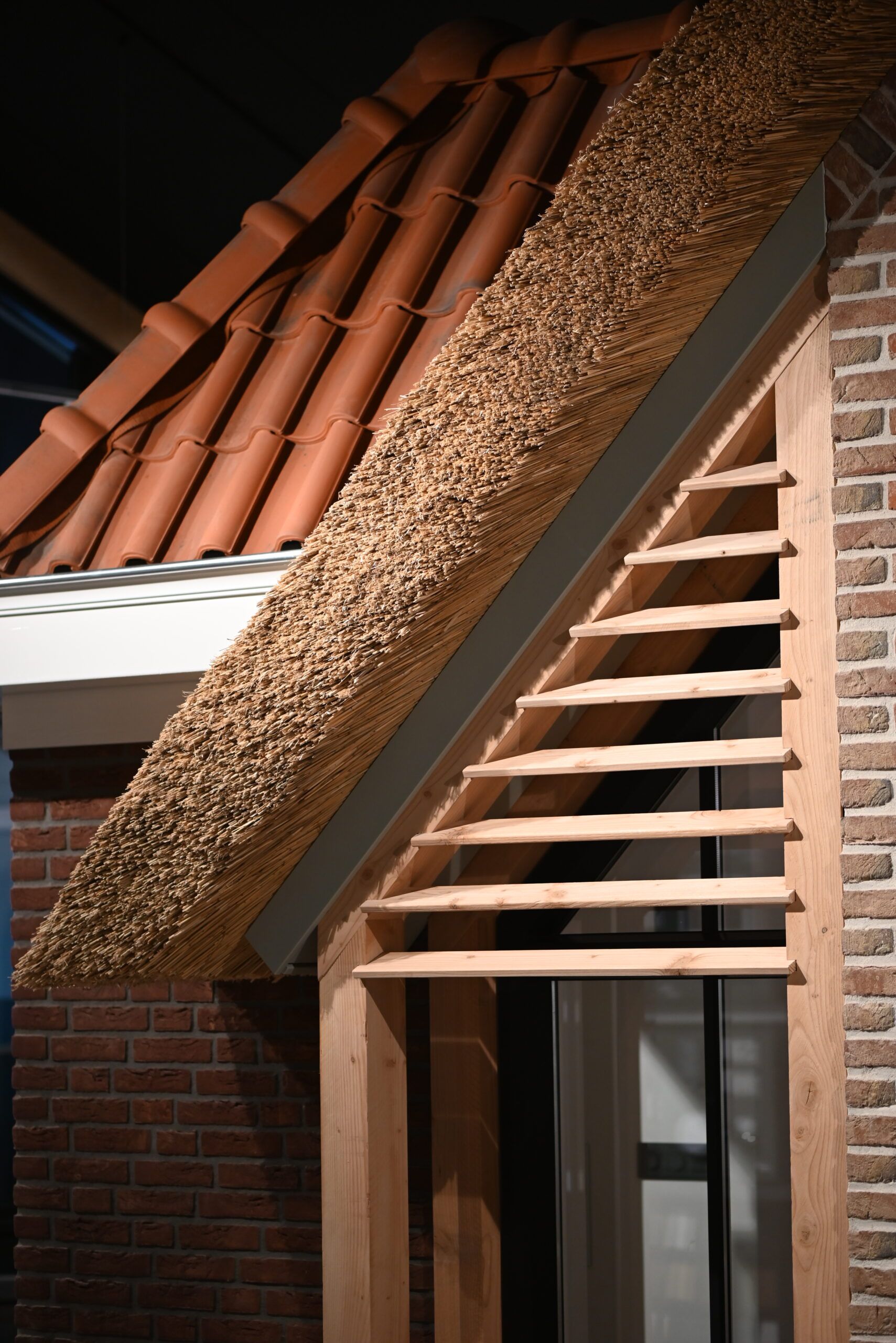 Detail van een dak met riet en keramische dakpannen in de showroom van Van Wiggen Bouw in Vianen