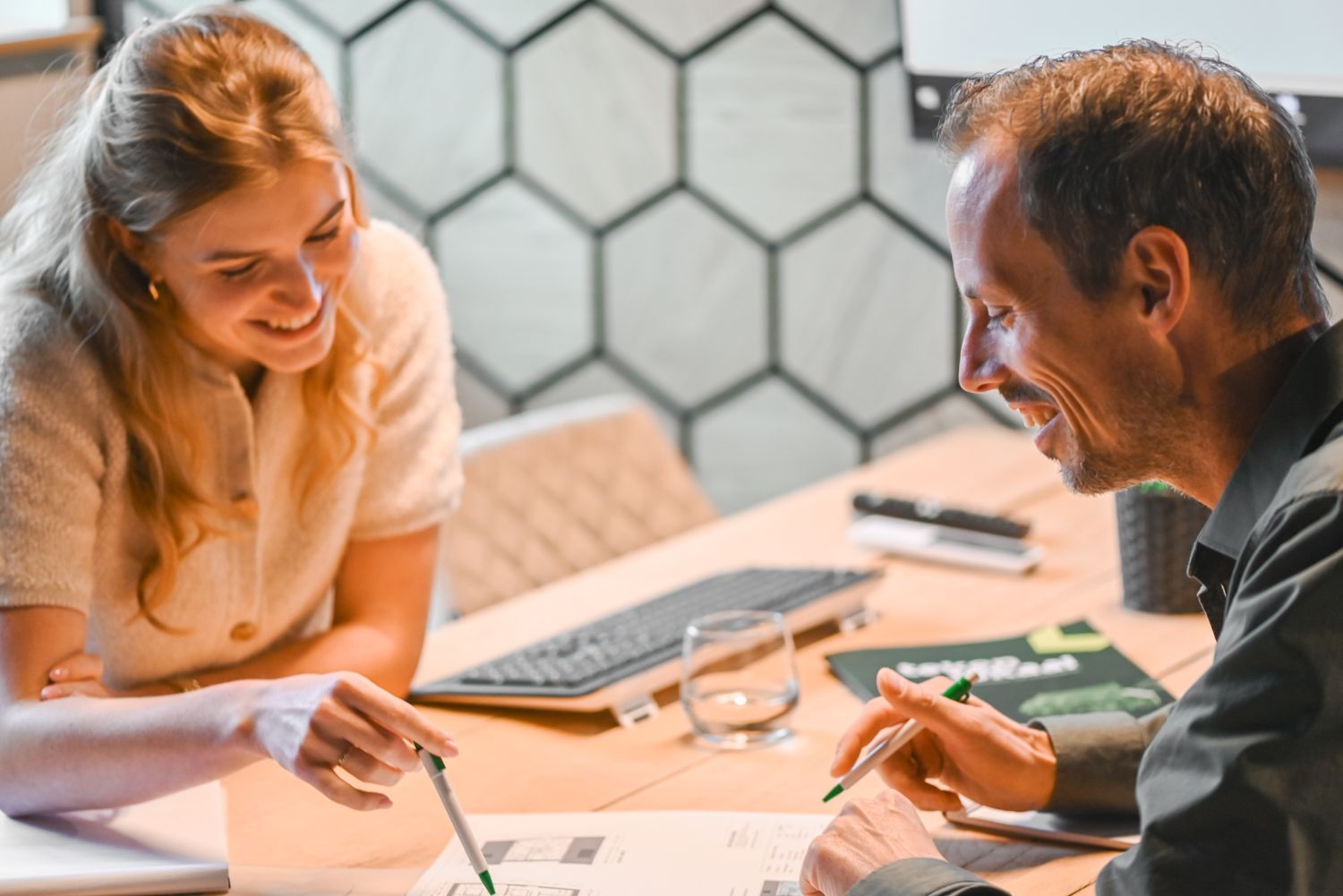 Twee personen in overleg aan tafel over bouwplannen bij Van Wiggen Bouw in Vianen