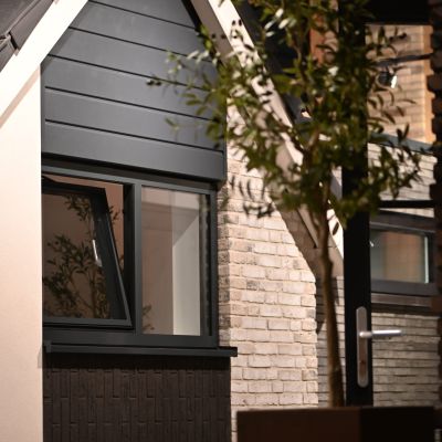 Detail van een moderne woninggevel met zwarte geveldelen, metselwerk en aluminium kozijnen in de showroom van Van Wiggen Bouw in Vianen