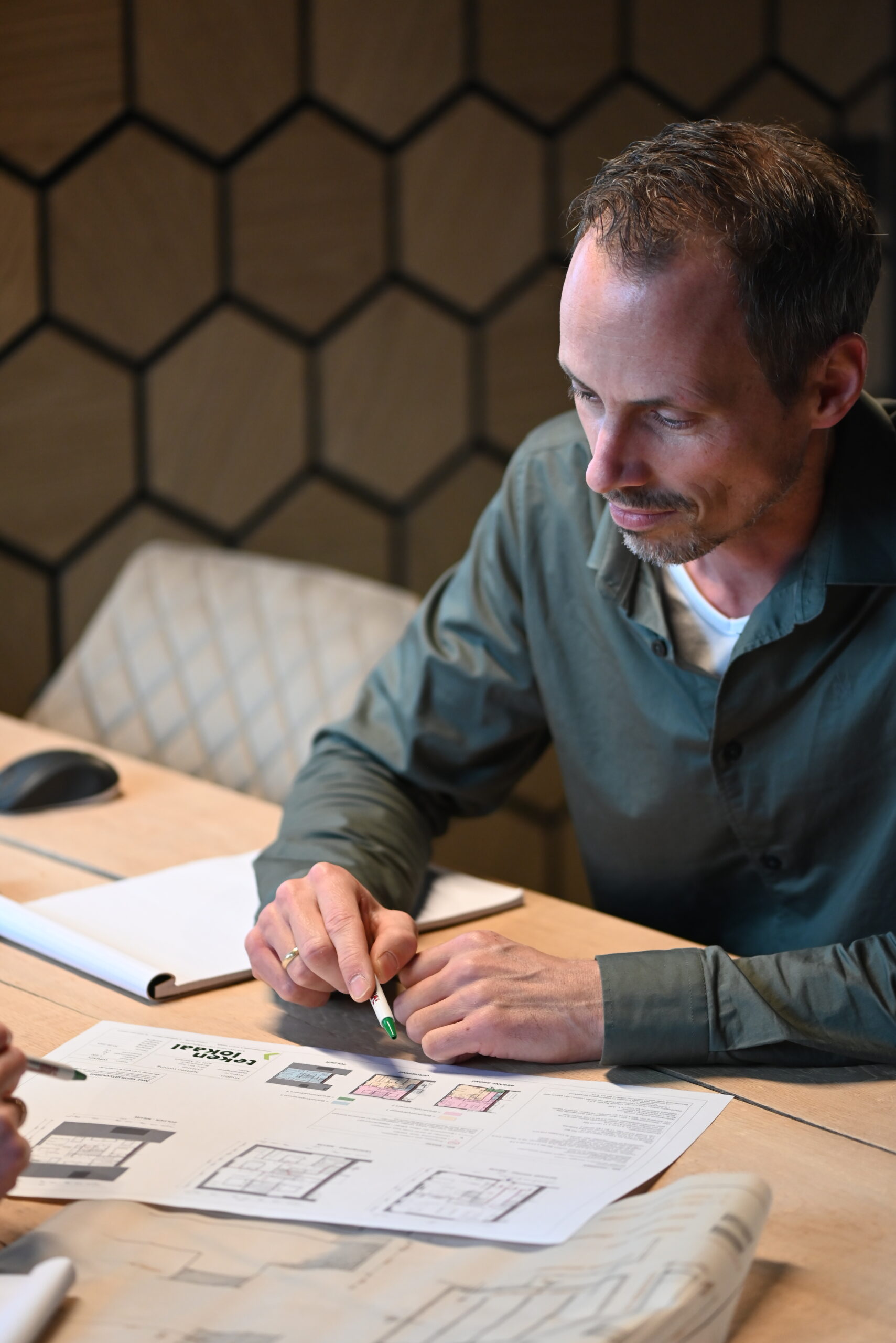 Man bekijkt en bespreekt bouwtekeningen aan tafel bij Van Wiggen Bouw in Vianen