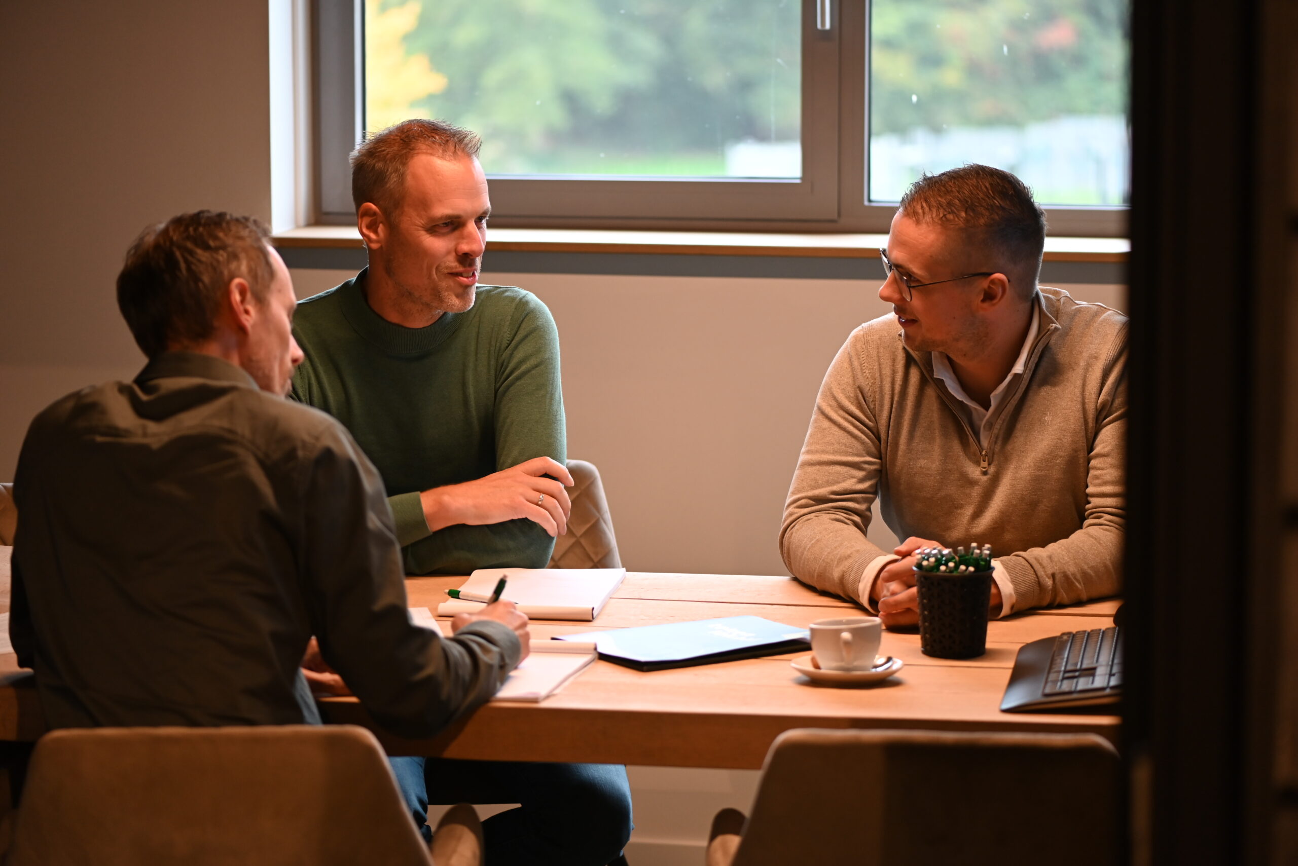 Drie collega’s in gesprek tijdens een teamoverleg bij Van Wiggen Bouw in Vianen
