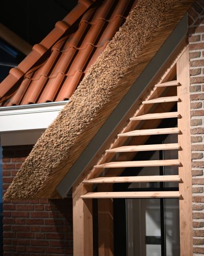 Detail van een dak met riet en keramische dakpannen in de showroom van Van Wiggen Bouw in Vianen