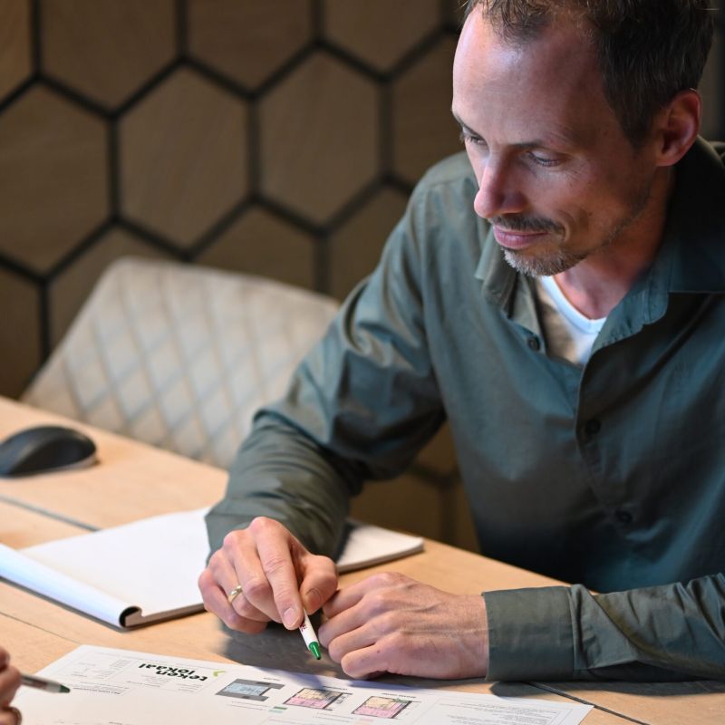 Man bekijkt en bespreekt bouwtekeningen aan tafel bij Van Wiggen Bouw in Vianen