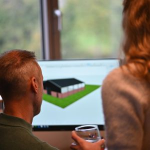 Twee collega’s bekijken een 3D-model van een woningontwerp op de computer bij Van Wiggen Bouw in Vianen